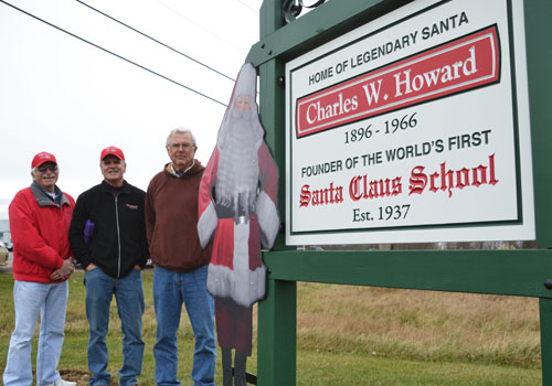 Joe Gehl, Gary Kent and Gary Derwick are pictured by the sign honoring Charles Howard on Route 98 in Albion.
